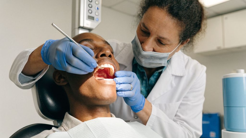 Dentist examining patient's gums during dental visit